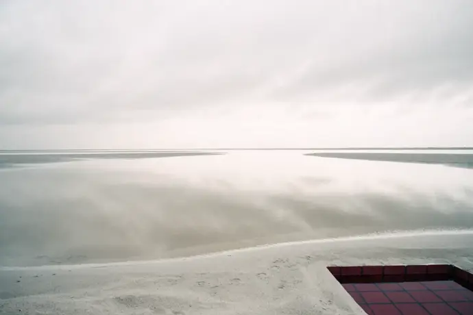 A wide, shallow tidal pool with one deep section lined in crimson tiles