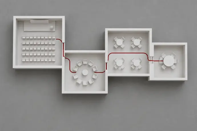 White architectural model of four connected meeting room layouts joined by a single crimson line