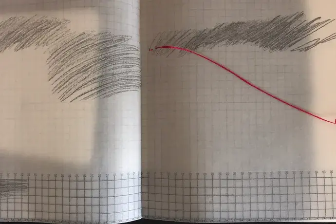 Layered tracing paper with a machine grid beneath hand-drawn strokes